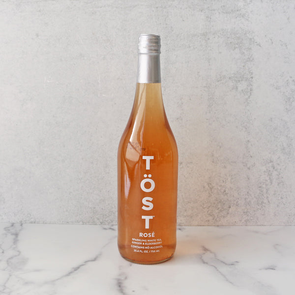 Tost non alcoholic Rose bottle on a white stone background
