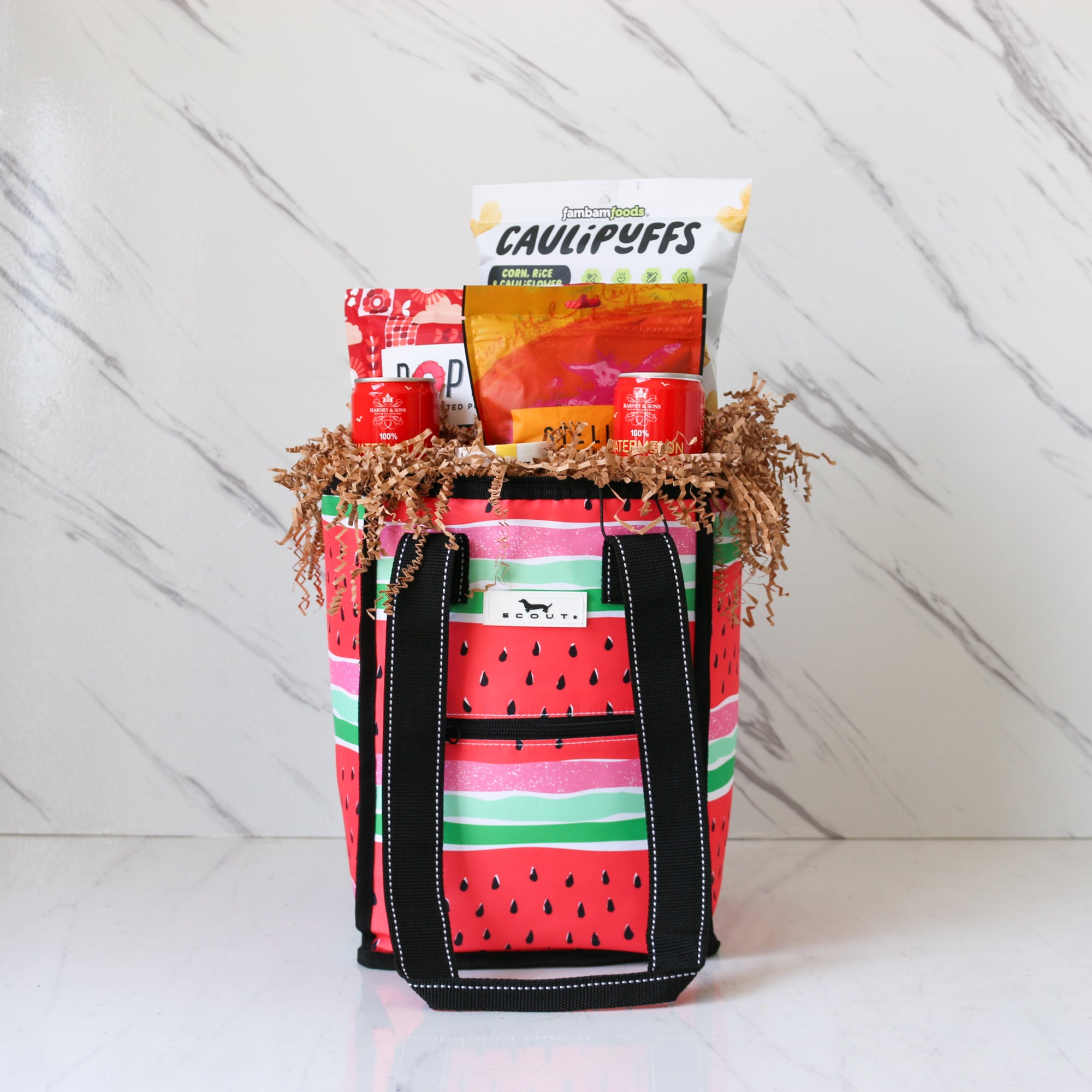 Tote bag with watermelon pattern filled with snacks on a white background