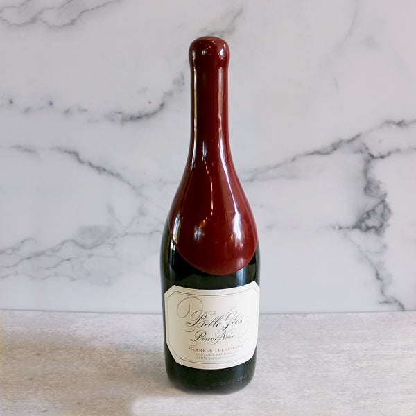 A bottle of Belle Glos Clark & Telephone Pinot Noir wine positioned against a marble background.