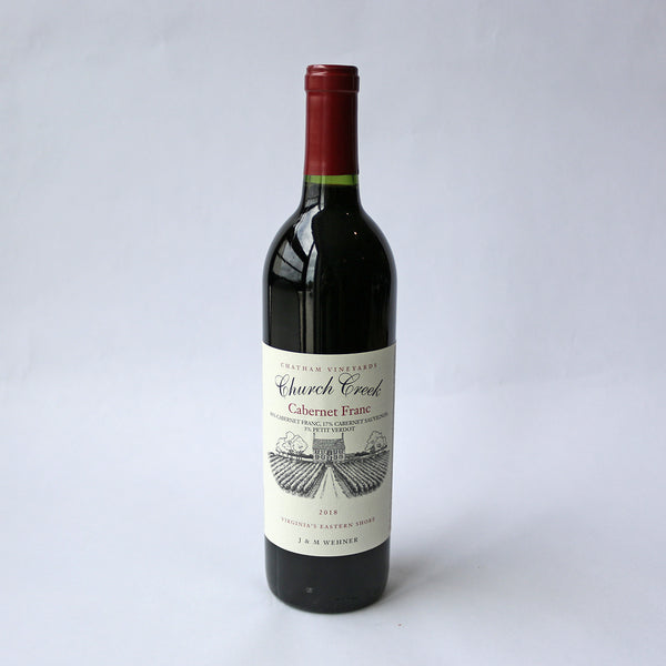 A bottle of Church Creek Cabernet Franc wine with a red cap and label, indicating it is a product of Chatham Vineyards, Eastern Shore, Virginia.