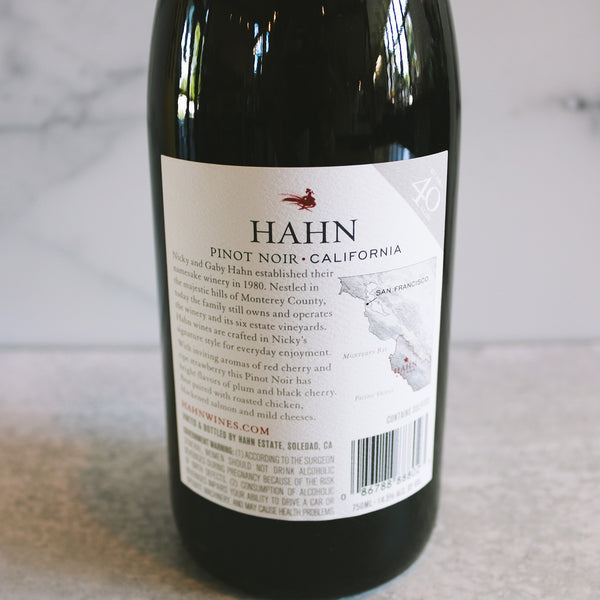 A bottle of Hahn Pinot Noir displayed on a white marble background. 