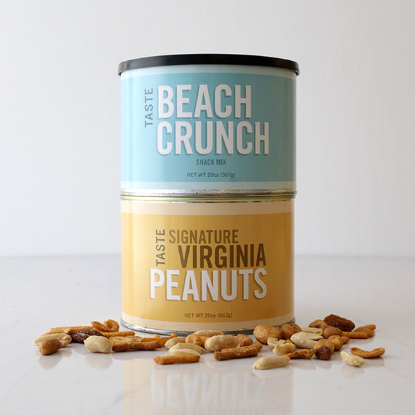 A tin container with two compartments, one labeled 'BEACH CRUNCH' and the other ' Signature VIRGINIA PEANUTS', alongside scattered peanuts and snacks.