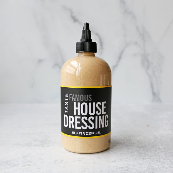 A 12oz squeeze bottle of TASTE House Dressing on a marble background.