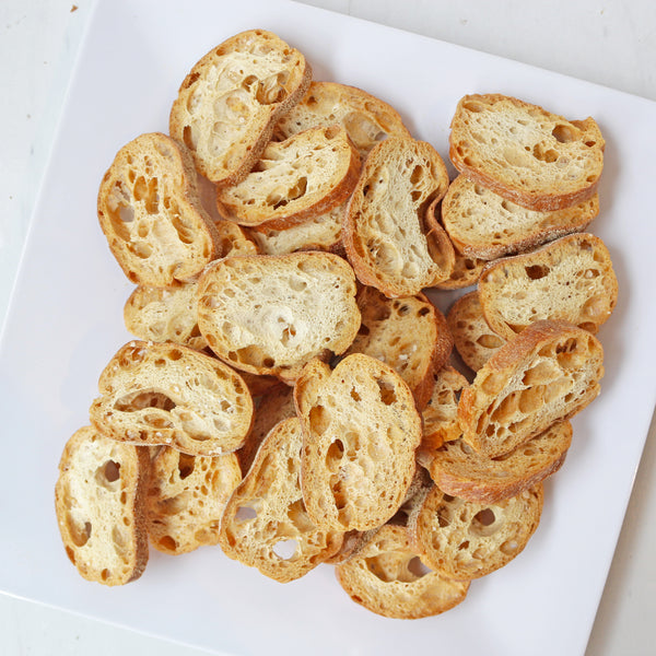 A plate of golden-brown TASTE Bakehouse crostini.