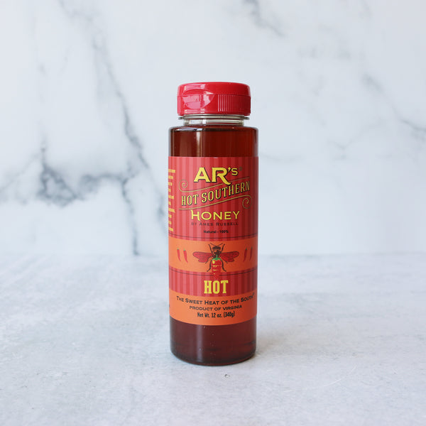 A 12oz squeezable plastic bottle of AR's Hot-Hot Southern Honey with a red flip-top cap, labeled for retail sale.