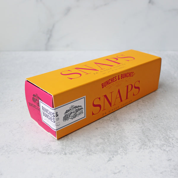 A box of Bunches & Bunches Snaps Ginger Cookies on a marble surface.