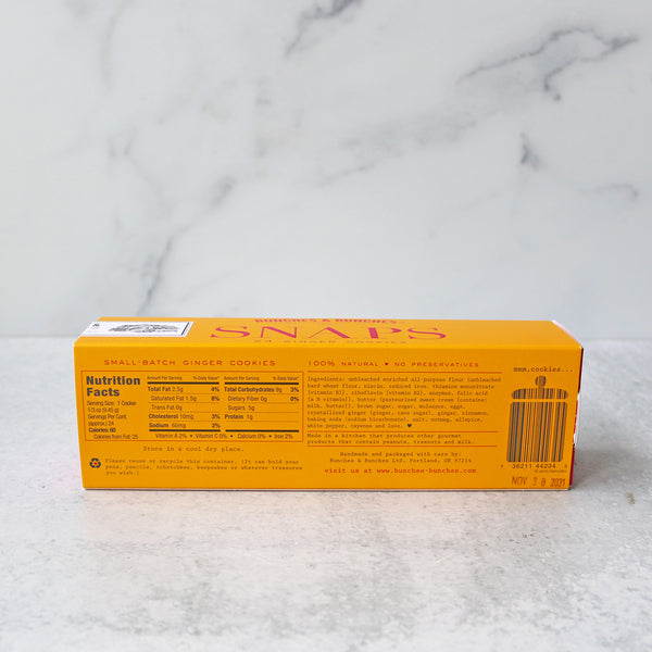 A box of Bunches & Bunches Snaps Ginger Cookies on a marble surface.