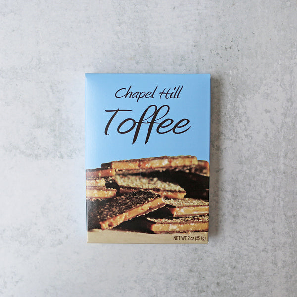 A box of Chapel Hill Toffee featuring a picture of the toffee candy with pecans and dark chocolate on the front.