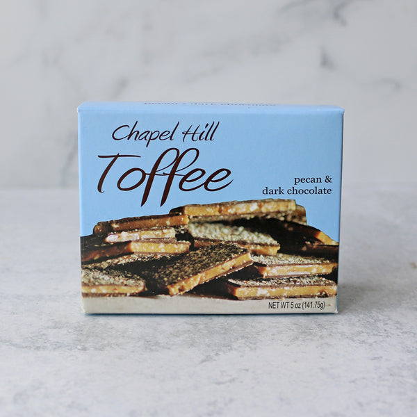 A box of Chapel Hill Toffee with pecan and dark chocolate flavors, displaying the toffee pieces on a blue background.