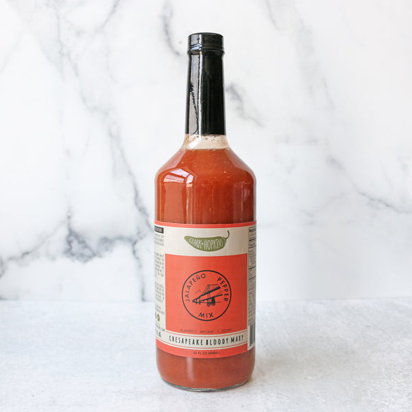 A bottle of Clark + Hopkins Chesapeake Bloody Mary Mix on a marble surface with a label that includes the product name and 'Gluten Free' text.