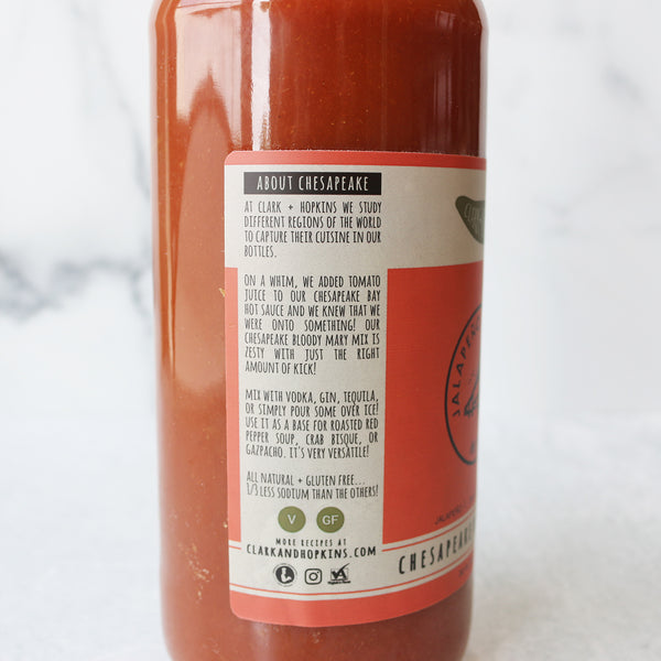 A bottle of Clark + Hopkins Chesapeake Bloody Mary Mix on a marble surface with a label that includes company info