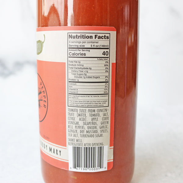 A bottle of Clark + Hopkins Chesapeake Bloody Mary Mix on a marble surface with a label that includes nutrition facts. 