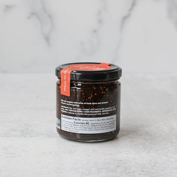A jar of Divina Orange Fig Spread on a marble background. Shows nutrition facts