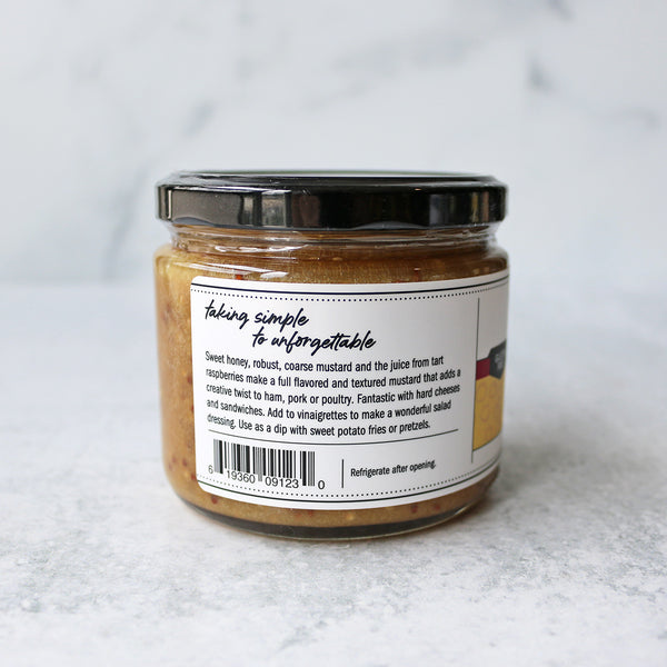 A jar of Terrapin Ridge Farms Raspberry Honey Mustard Pretzel Dip on a marble surface showing text
