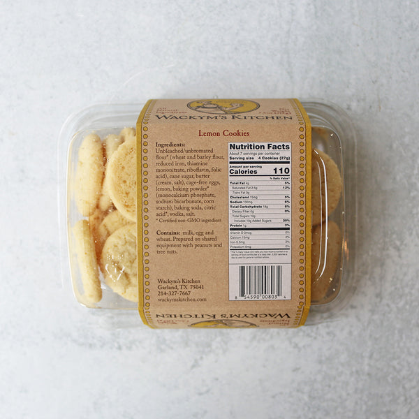 A clear plastic tub containing lemon cookies with a brown label that reads 'Wackym's Kitchen All Natural Crunchy Cookies Lemon'.